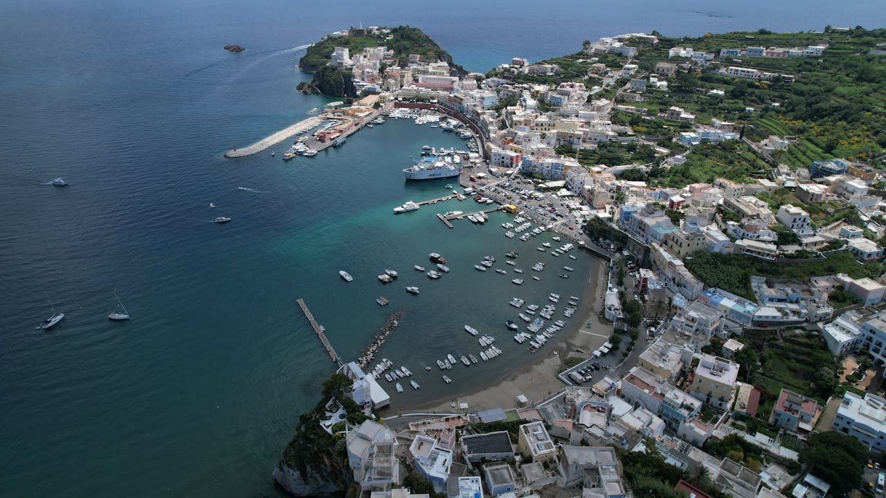 A stunning aerial view of Ponza Island harbor with boats and coastal town in summer.